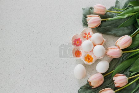 Photo for Happy Easter! Beautiful tulips and natural eggs on modern table. Stylish easter flat lay with copy space. Handmade egg holder with pink tulips - Royalty Free Image