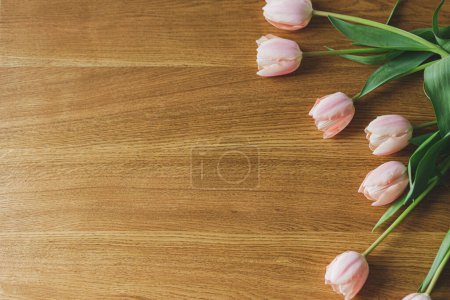 Photo for Beautiful tulips flat lay on wooden table with space for text. Modern easter decor. Stylish pink tulips bouquet. Happy mothers day and womens day - Royalty Free Image
