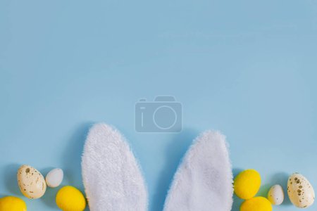 Photo for Stylish Easter eggs and bunny ears flat lay on blue background with copy space. Happy Easter! Greeting card template. Modern holiday banner. Easter hunt, minimal composition - Royalty Free Image