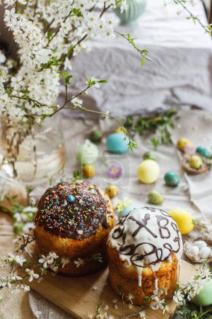 Photo for Homemade easter bread and natural dyed easter eggs with spring flowers on linen napkin on rustic table. Traditional Easter food. Happy Easter! - Royalty Free Image