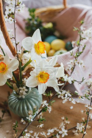 Photo for Beautiful daffodils on background of stylish natural dyed easter eggs with spring flowers on linen napkin in wicker basket. Rustic Easter still life. Happy Easter! - Royalty Free Image