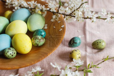Photo for Stylish natural dyed easter eggs on wooden plate with spring flowers on rustic table. Happy Easter! Rustic Easter still life - Royalty Free Image