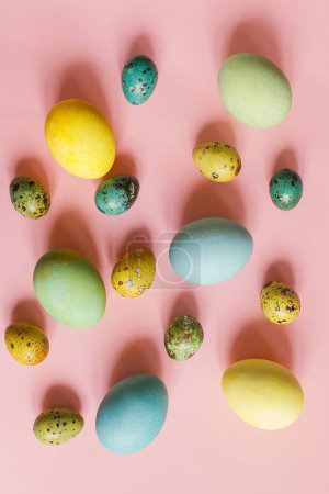 Foto de Pascuas planas. Elegantes huevos de Pascua sobre fondo rosa. ¡Feliz Pascua! Composición natural de huevos coloridos pintados. Tarjeta de felicitación moderna o banner - Imagen libre de derechos