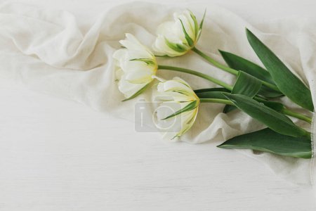 Foto de Hermosos tulipanes blancos con tela suave sobre mesa de madera rústica con espacio para el texto. Feliz Día de las Madres. Ramo de primavera del jardín. Día de las mujeres - Imagen libre de derechos
