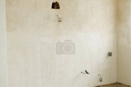 Photo for Unfinished room with electricity wires, plaster walls and dirt in new building. Construction of house and home renovation concept. Home improvement, cabling - Royalty Free Image