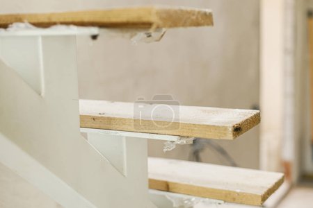 Téléchargez les photos : Escaliers en bois inachevés au deuxième étage dans un nouveau bâtiment. Construction de la maison et concept de rénovation résidentielle - en image libre de droit