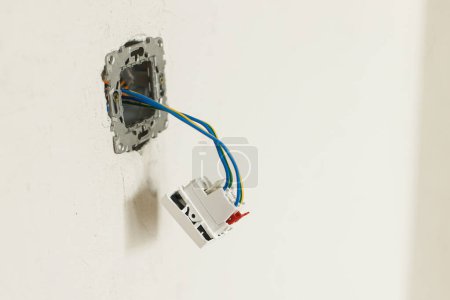 Photo for Electric box with socket and switch. Installing electricity connector in plastered wall. Construction of house and home renovation concept. Cabling - Royalty Free Image