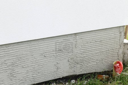 Foto de Renovación de fachadas, aislamiento con lana mineral y paredes de yeso blanco. Moderna renovación de casa de campo. Concepto de aislamiento de la casa, mejora térmica y ahorro energético - Imagen libre de derechos