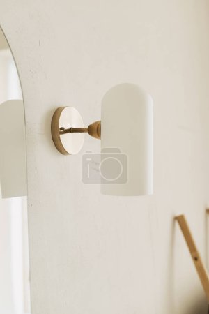 Photo for Stylish bathroom design detail. Modern lamp on wall at mirror, modern bathroom interior. Brass and white glass lamp - Royalty Free Image