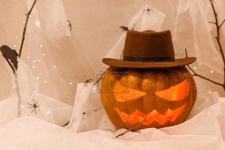 Foto de Spooky Jack o linterna calabaza tallada, tela de araña, fantasma, murciélagos y luz brillante en la noche. ¡Feliz Halloween! Espeluznantes decoraciones atmosféricas fiesta de halloween, espacio para el texto. Truco o trato - Imagen libre de derechos