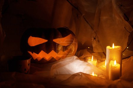 Foto de Spooky Jack o linterna calabaza tallada, telaraña, fantasma, arañas y luz brillante en la oscuridad. ¡Feliz Halloween! Espeluznantes decoraciones atmosféricas fiesta de halloween, espacio para el texto. Truco o trato - Imagen libre de derechos