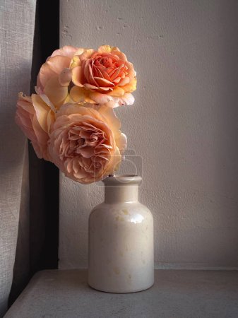 Foto de Hermosas rosas pastel en jarrón sobre fondo rústico. Flores con estilo naturaleza muerta, composición artística. Papel pintado vertical floral - Imagen libre de derechos