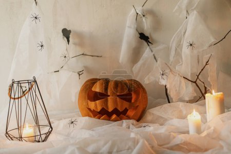 Foto de Spooky Jack o linterna calabaza tallada, telaraña, fantasma, murciélagos y velas brillantes en la noche. ¡Feliz Halloween! Espeluznantes decoraciones atmosféricas fiesta de halloween, espacio para el texto. Truco o trato - Imagen libre de derechos