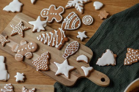 Photo for Christmas gingerbread cookies with icing flat lay on festive rustic table. Merry Christmas! Delicious gingerbread cookies, atmospheric holiday time - Royalty Free Image