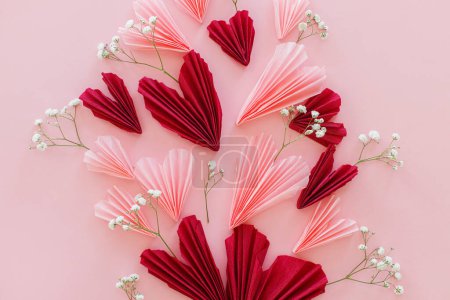 Téléchargez les photos : Joyeuse Saint Valentin ! Coeurs roses et rouges élégants avec des fleurs douces à plat posé sur fond rose. Valentines coeurs découpes de papier. Concept de fête de l'amour et des mères - en image libre de droit