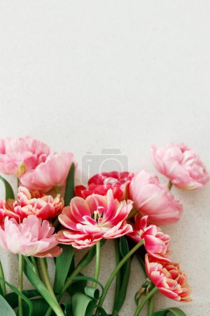 Photo for Modern tulips flat lay on grey stone background. Happy Valentines day and happy mother's day bouquet. Stylish beautiful floral wallpaper with space for text. Tender red and pink flowers banner - Royalty Free Image