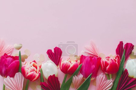 Foto de Valentine estaba acostado. Elegantes corazones y tulipanes rosados y rojos bordean el fondo rosado. Feliz día de San Valentín y feliz día de las madres. Tarjeta de felicitación y plantilla de banner, espacio para texto - Imagen libre de derechos