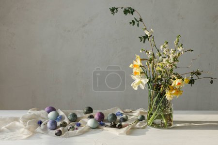 Photo for Happy Easter! Stylish easter eggs and spring flowers bouquet on rustic wooden table in rural room. Easter modern simple decor, natural painted marble eggs. Season's greetings - Royalty Free Image