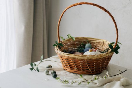 Photo for Happy Easter! Stylish easter basket with natural dyed eggs, meat, bread, butter, beets and spring flowers on rustic table. Traditional easter orthodox holiday food and cherry bloom - Royalty Free Image