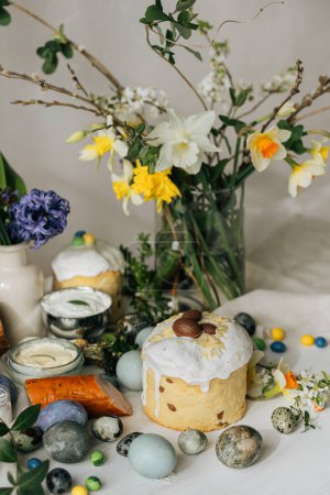 Photo for Happy Easter! Stylish easter natural dyed eggs, meat, bread, butter, beets, basket and flowers on rustic table. Traditional easter orthodox holiday food for blessing and daffodils bouquet - Royalty Free Image