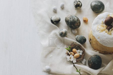 Photo for Happy Easter! Stylish easter eggs, homemade easter bread and spring flowers on linen napkin on rustic table. Natural painted marble eggs and cherry blooms, minimal flat lay - Royalty Free Image