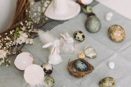 Photo for Stylish easter eggs, bunnies and cherry blossom composition on rustic table. Happy Easter! Modern natural dyed marble eggs and spring flowers. Rural still life - Royalty Free Image