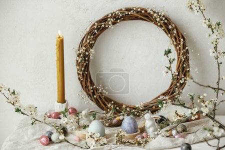 Photo for Happy Easter! Stylish easter eggs, bunnies and cherry blossom on rustic table. Modern natural dyed and chocolate colorful eggs and spring flowers. Easter still life decor in countryside home - Royalty Free Image