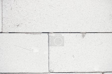 Foto de Aerated concrete blocks wall. Autoclaved aerated concrete blocks  masonry close up with adhesive. Process of house building at construction site. Aerated concrete blocks wallpaper pattern - Imagen libre de derechos