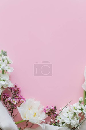 Foto de Flores elegantes planas yacen sobre fondo rosa con espacio para el texto. Feliz día de las mujeres y día de las madres. Hermosos tulipanes y flores de primavera borde, plantilla de tarjeta de felicitación. Banner floral - Imagen libre de derechos