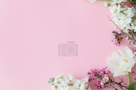 Foto de Flores elegantes planas yacen sobre fondo rosa con espacio para el texto. Feliz día de las mujeres y día de las madres. Hermosos tulipanes y flores de primavera borde, plantilla de tarjeta de felicitación. Banner floral - Imagen libre de derechos