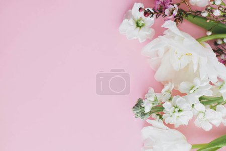 Téléchargez les photos : Fleurs élégantes plat posé sur fond rose avec de l'espace pour le texte. Joyeuse journée des femmes et fête des mères. Belle bordure de tulipes et fleurs printanières, modèle de carte de vœux. Bannière florale - en image libre de droit