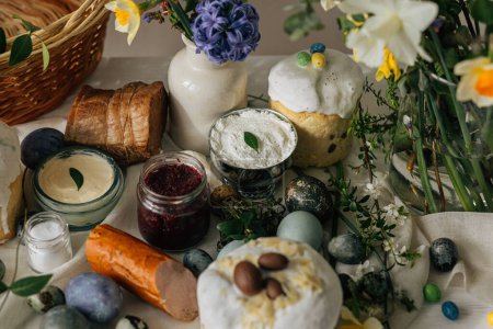 Photo for Happy Easter! Stylish easter natural dyed eggs, meat, bread, butter, beets, basket and flowers on rustic table. Traditional easter orthodox holiday food for blessing and daffodils bouquet - Royalty Free Image