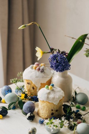 Elegantes huevos de Pascua, panettone, flores de primavera y huevos de chocolate en la mesa de madera rústica. Huevos de mármol de tinte natural, flor y comida de vacaciones. Bodegón festivo. Feliz Pascua!