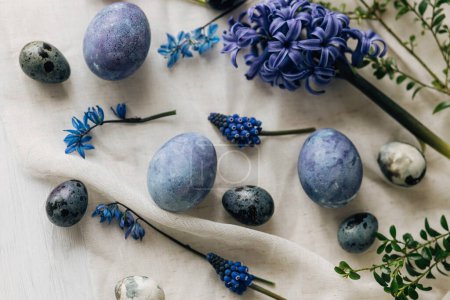 Foto de Pascuas planas. Elegantes huevos de Pascua y flores de primavera en servilleta de lino en la mesa rústica. ¡Feliz Pascua! Mármol pintado natural y huevos azules, flores de jacinto. Bodegón moderno - Imagen libre de derechos