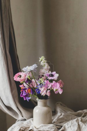 Téléchargez les photos : Bouquet élégant sur fond de lin rustique. Belle anémone colorée, ranunculus, lathyrus scabiosa en vase. Fleurs d'été, nature morte d'humeur florale. Espace pour le texte - en image libre de droit