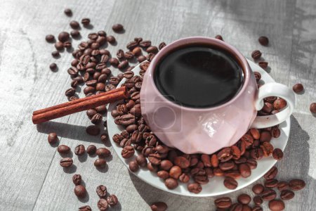 Téléchargez les photos : Tasse de café sur l'assiette avec cannelle sur la table et grains de café autour - en image libre de droit