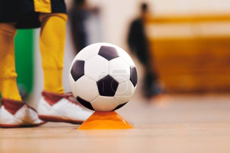 Youth futsal league. Indoor football player with classic soccer ball. Indoor soccer sports hall. Football futsal player, ball, futsal floor. Sports background