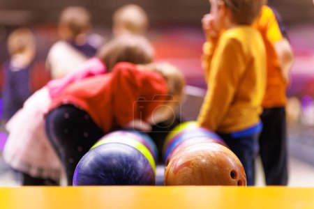 Les enfants jouent au bowling. Activités parascolaires pour les enfants. Boules de bowling et bowling en arrière-plan