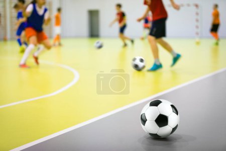 Téléchargez les photos : Cours de soccer intérieur pour enfants. Aptitudes au football. Joueurs de futs dans le jeu de pratique au gymnase - en image libre de droit