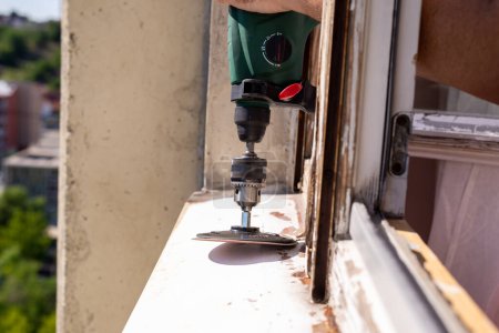 Téléchargez les photos : Machine during sanding rust from an old window cill - en image libre de droit