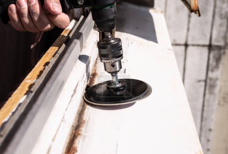 Téléchargez les photos : Machine during sanding rust from an old window sill - en image libre de droit