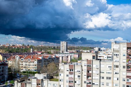 Photo for Stormy sky and rainy clouds above a quarter of city residential buildings - Royalty Free Image
