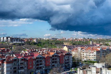 Photo for Stormy sky and rainy clouds above a quarter of city residential buildings - Royalty Free Image