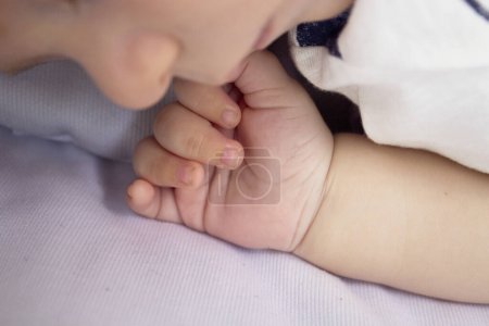 Zwei Monate alte Babyhand. Blauer Hintergrund