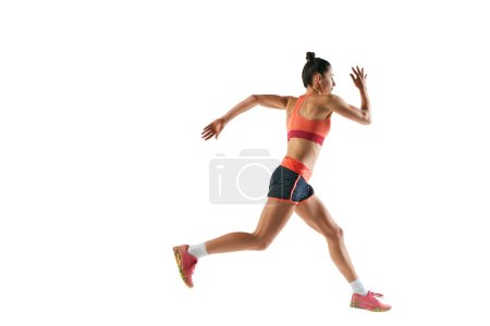 Dynamic portrait of professional female athlete, runner or jogger wearing summer sportswear running isolated on white background. Sport, fitness, energy, movements concept