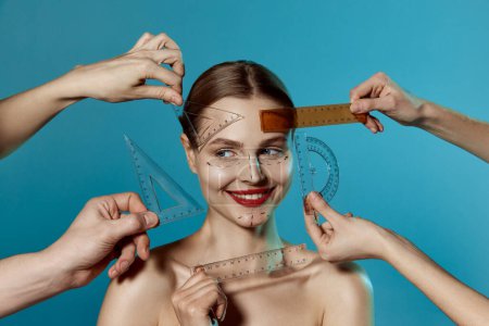 Photo for Making beauty, modifying face to make non-surgical or surgical correction, plastic surgery. correction of asymmetry. Young woman, female patient isolated on blue studio background. Concept of lifting - Royalty Free Image