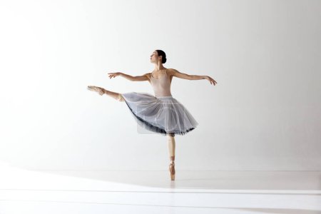Ballerina. Young graceful woman ballet dancer dressed in professional outfit demonstrating dancing skill. Beauty of classic ballet. Concept of inspiration, beauty, dance, creativity