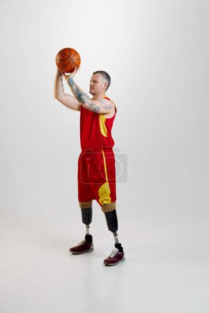 Photo for Attractive, confident, sporty man with prosthetic legs, disability in uniform with basketball ball in motion. Sport for people with disabilities. concept of sport, player, medical, health, body care. - Royalty Free Image