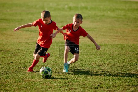 Photo for Full length portrait of kid soccer players on match in motion. Playing football on the sports field. Childrens team games. Concept of sport, healthy lifestyle, hobbies, leisure activity. Ad. - Royalty Free Image