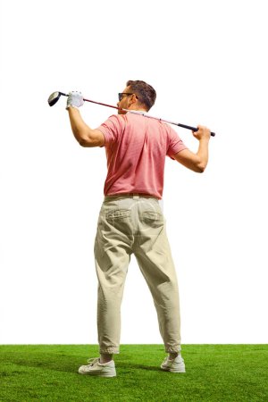 Back view. Professional golfer hit sweeping driver after hitting golf ball down fairway at golf club. Hobby in holiday and vacation with friends. Concept of game, sport, recreation, healthy lifestyle.